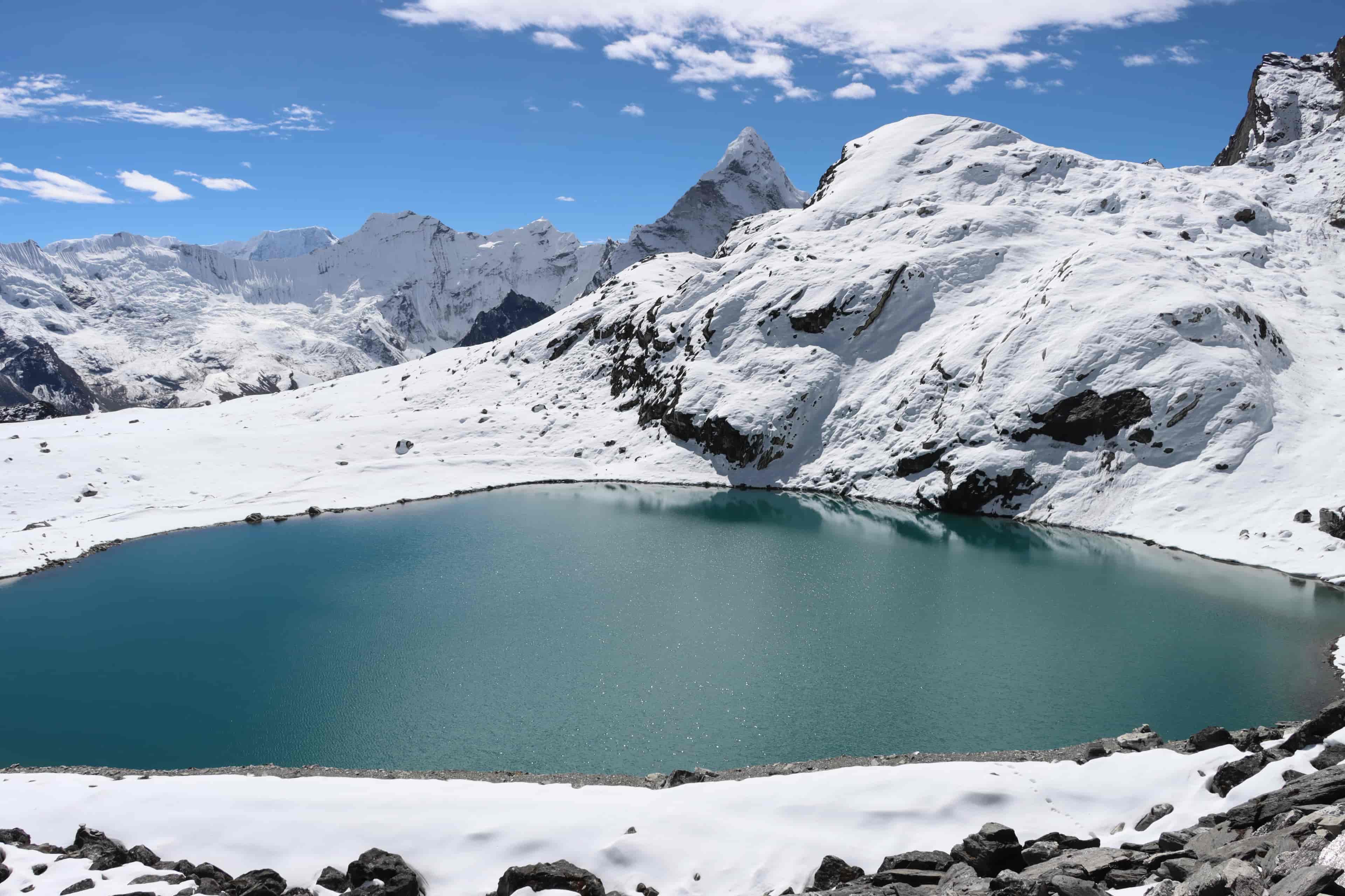Scenic view of a lake by Kongma La Pass framed by snowy ridges and Ama Dablam in the backdrop