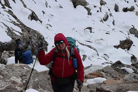 Happy trekker walking on snow-covered trail to Renjo La Pass in Everest region, Nepal