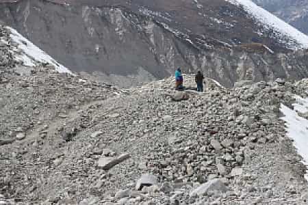 Adventurers trekking across Ngozumpa Glacier with icy ridges and winding moraines