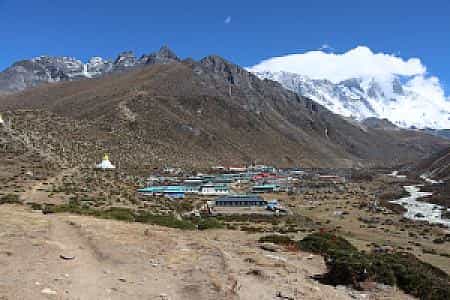 Prayer flags and stone houses of Dingboche with panoramic views of the Khumbu mountains