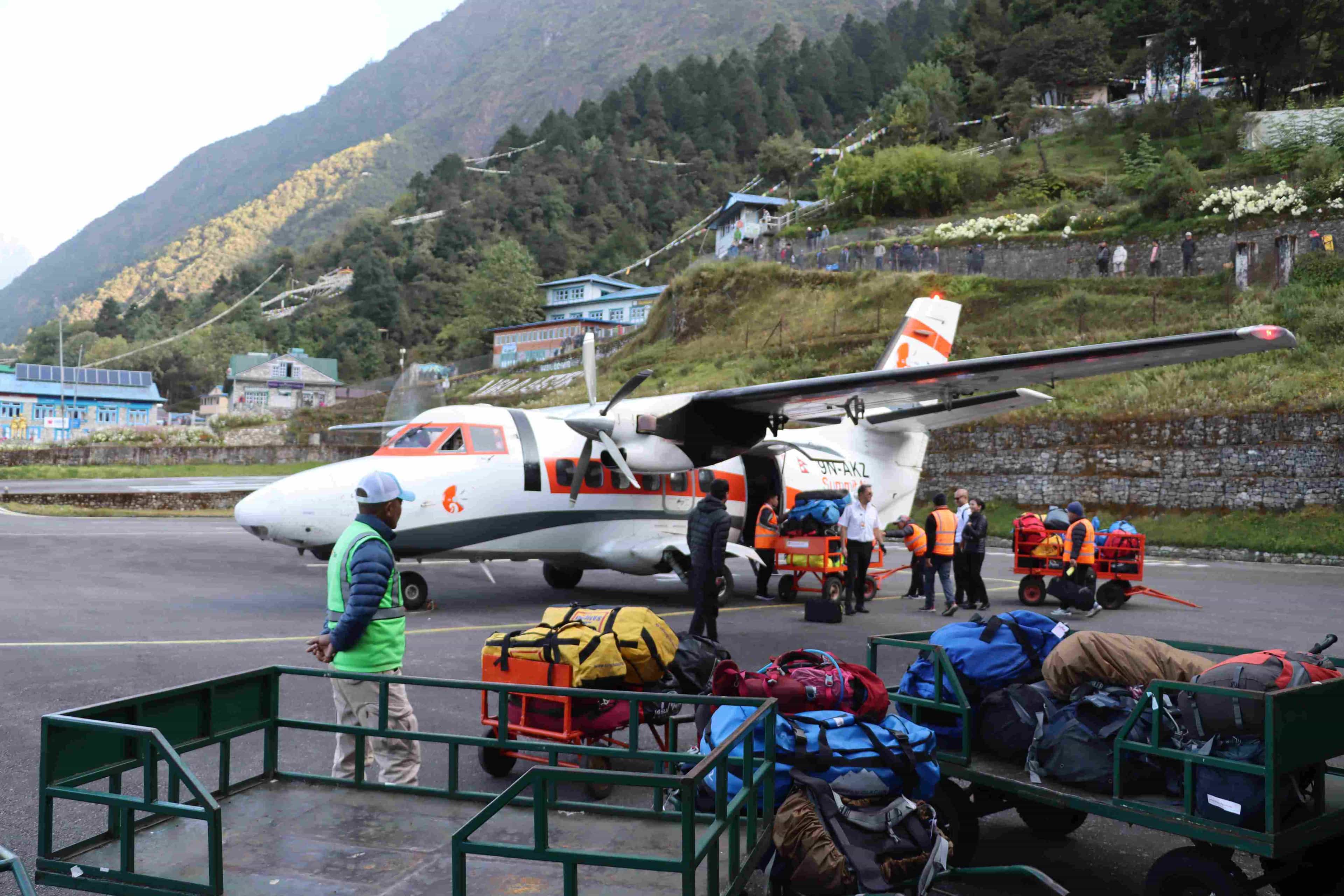 Small aircraft at Lukla Airport being loaded with trekking bags, illustrating strict Lukla flight weight limits for passengers and luggage.